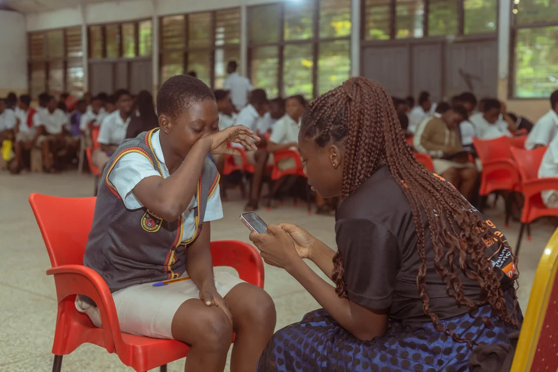 A practitioner speaking with a student during a Snuggli Health outreach in Ghana